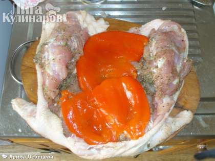 Наполнить курицу начинкой, сначала уложить пластины перца, чтобы они плотно были прижаты к мясу.