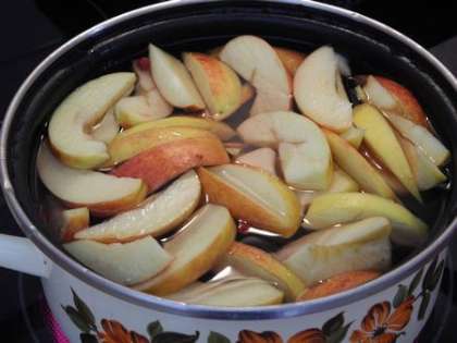 В кастрюлю налить воду, добавить яблоки и бруснику