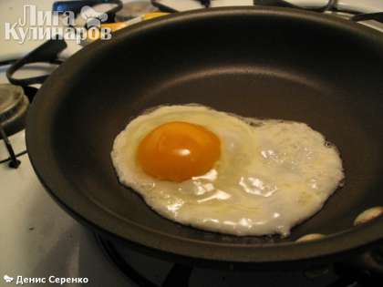 Аккуратно разбиваем яйца над сковородой и жарим на среднем огне, пока белок полностью не будет готов.