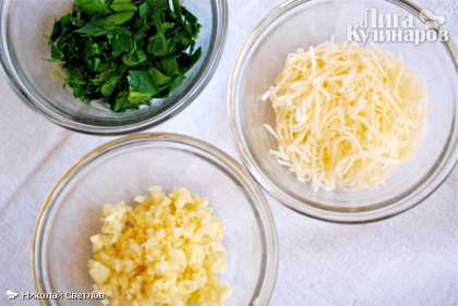 Смешиваем чесночную пасту с мелкопорубленной зеленью петрушки.  Намазываем каждую половинку багета смесью равномерно, посыпаем тертым сыром.
