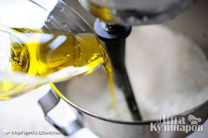 Далее, перемешивая миксером на низкой скорости, медленно вливаем оливковое масло. Перемешиваем, пока оливковое масло не смешается с мукой.
