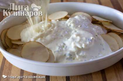 Обильно смажьте маслом форму для выпечки. Добавьте нарезанный картофель. Равномерно залейте картофель соусом.