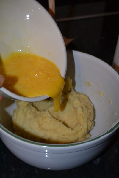 В отдельной посуде быстренько разбить и размешать яйца в омлет. Залить их в тесто, тщательно мешая деревянной ложкой. Сначала яйца не захотят вмешиваться, но через пару минут у вас получится гладкое тесто, которое легко мешать. Если хотите, то можно вмешать пару ложек рома для аромата.