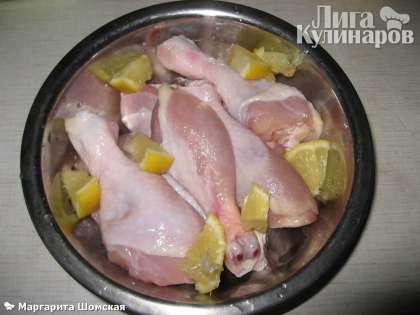Лимон разрезаем пополам, слегка выдавливаем сок и поливаем им курицу. Половинку лимона режем на небольшие кусочки и кладем к курице.