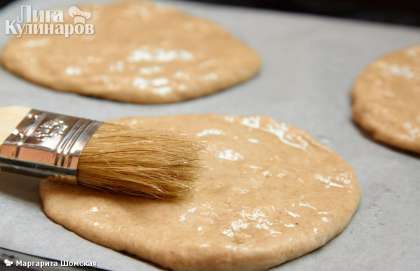 Противень застилаем пекарской бумагой или смазываем маслом, присыпаете мукой, на нее выкладываем лепешки и смазываем каждую сверху маслом.