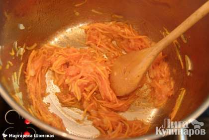 Кастрюлю с толстым дном ставим на плиту, на сильный огонь, наливаем масло, кладем лук и морковь, постоянно помешивая, обжариваем. Как лук станет прозрачным, добавляем натертый томат, перемешиваем и 30 секунд тушим.