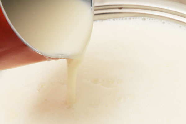 Когда молоко закипит уменьшите огонь и небольшой струйкой вливайте яичную смесь, одновременно помешивая молоко ложкой.
