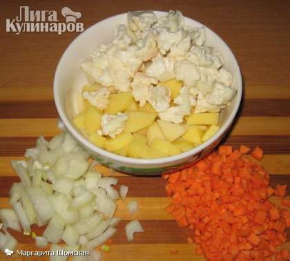 Нарезаем картофель, лук и морковь на кубики. Капусту разбираем на маленькие соцветия. Отправляем овощи по одному в бульон, после каждой закладки ждём закипания.