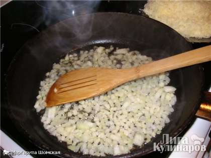На другой сковороде сначала обжариваем в растительном масле лук до полупрозрачности и мягкости (около 6 минут). Добавляем в сковороду перцы и сельдерей. Жарим 5 минут.
