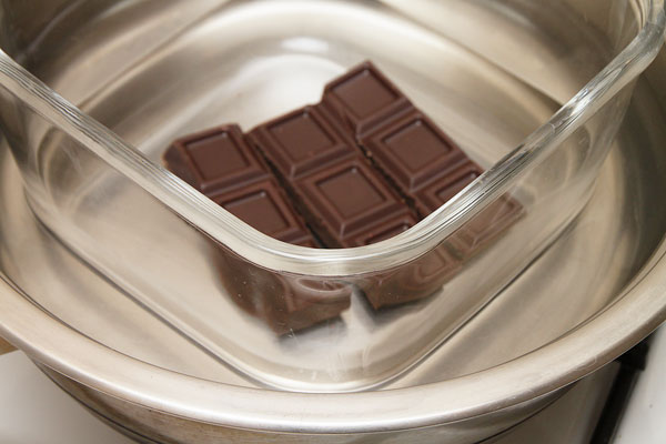 Масло вынуть из холодильника, чтобы не было очень твёрдым. Шоколад растопить на водяной бане и хорошо остудить, чтобы он был жидким, но при этом не мог растопить масло.