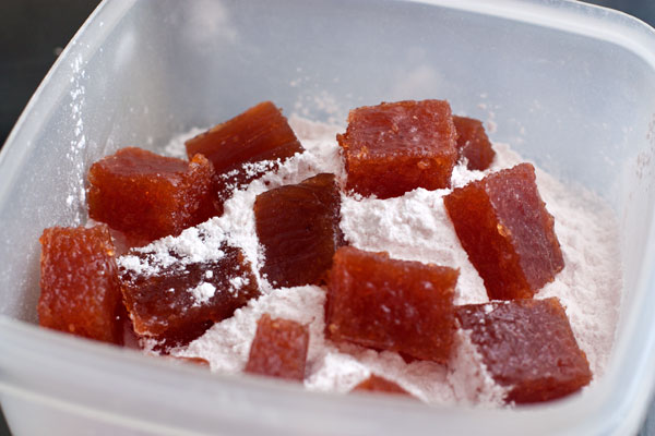 Обваляйте в сахаре или сахарной пудре, поместив кусочки в подходящую емкость с сахаром (пудрой). Емкость (или пакет) встряхните, затем вытащите кусочки мармелада.