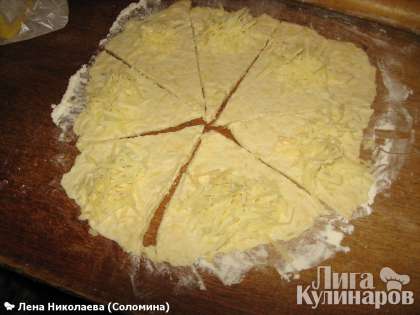 на каждую часть выложить по ложке тертого сыра для начинки и завернуть рогалики. Смазать взбитым яйцом