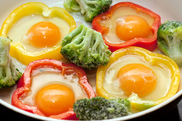 В каждое кольцо аккуратно вылейте по одному яйцу. Посолите и готовьте на небольшом огне, пока яичница не будет готова. Кстати, в просветах между перцем можно приготовить другие овощи или поджарить бекон.