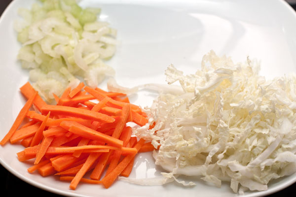 Морковь нарежьте тонкой соломкой или натрите на специальной терке для корейской моркови.   У стеблей сельдерея удалите волокна и нарежьте поперек либо вдоль, как морковь.  Китайский салат тонко нашинкуйте.