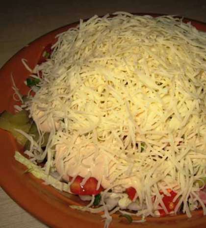 Салат мы перемешиваем с солью и перцем и заправкой из майонеза и сливок. Потом  салат посыпаем натертым сыром твердого сорта.
