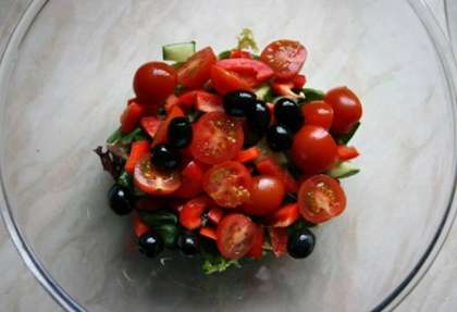 Огурцы, перец, помидоры нарежьте и уложите на зелень слоями. Итоговый шаг овощной подушки - поместите оливки поверх томата.