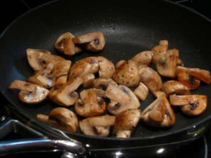 Подготавливаем грибы. Лучше использовать шампиньоны. Если грибы крупные, то их можно нарезать пополам. Обжариваем грибы на среднем огне. Посолим и поперчим их. Если образовалась влага, то е нужно выливать ее из сковороды, так как может потеряться грибной вкус.