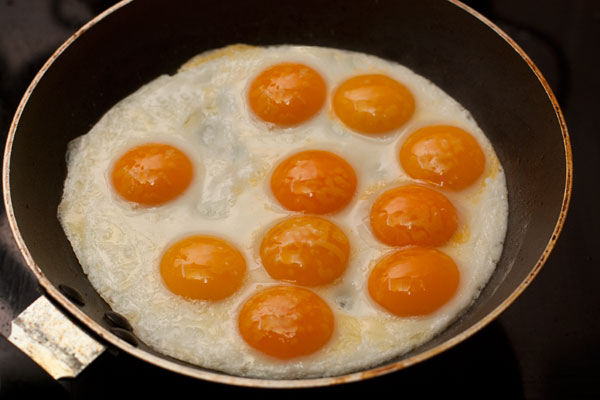 Посолите и готовьте на небольшом огне, чтобы яйца успели прогреться и не подгореть. В готовой яичнице-глазунье белки должны схватиться, а желтки остаться кремовыми.