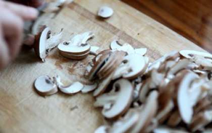 Хорошо промыть шампиньоны теплой водой. Затем ножом нужно измельчить грибы небольшими пластиночками и переложить в свободную миску.