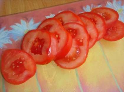 Для начала аккуратно нарежьте помидоры тонкими кружочками. Таким же образом нарезаем колбасные изделия.