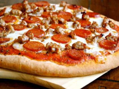 Сверху выложите сыр, после колбасу и бекон. Выпекайте пиццу на протяжении 15 минут в разогретой духовке до 180С.