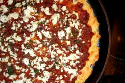Теперь основу равномерно смазываем соусом, сверху присыпьте тертым сыром. Выпекайте пиццу 5-7 минут. Как только сыр подрумянился, ваша домашняя пицца готова. Можно подавать на стол, присыпав зеленью.