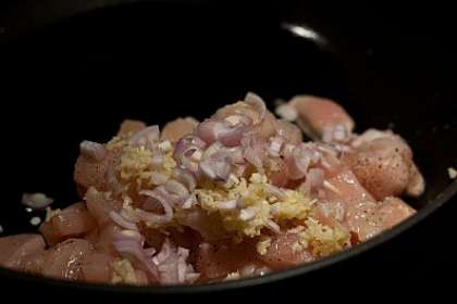 Разогреть на сковороде оливковое масло. Положить в нее курицу, лук и чеснок. Обжаривать все ингредиенты минут 10 до полуготовности. Посолить и поперчить. Переложить содержимое сковороды на тарелку.