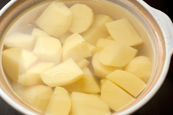 Почистите картошку и сразу же опускайте ее в холодную воду,  чтобы она не темнела. Старайтесь нарезать ее одинаковыми кусочками, чтобы они все приготовились одновременно.