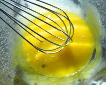 В отдельной емкости соединяем яичный желток с измельченным чесноком. Постепенно добавляем растительное масло тонкой струйкой, при этом постоянно перемешиваем компоненты.