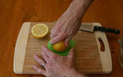 Промойте лимон под проточной водой и разрежьте его на две половины. Своими руками или с помощью соковыжималки выжмите лимонный сок.