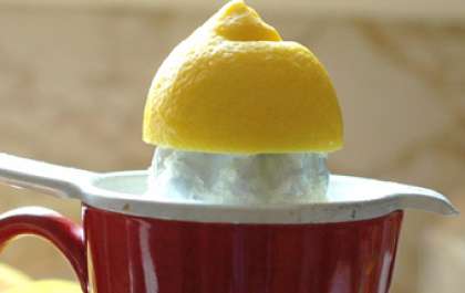 Промойте лимон и разрежьте напополам. С помощью ручной соковыжималки отожмите 3 столовые ложки лимонного сока.