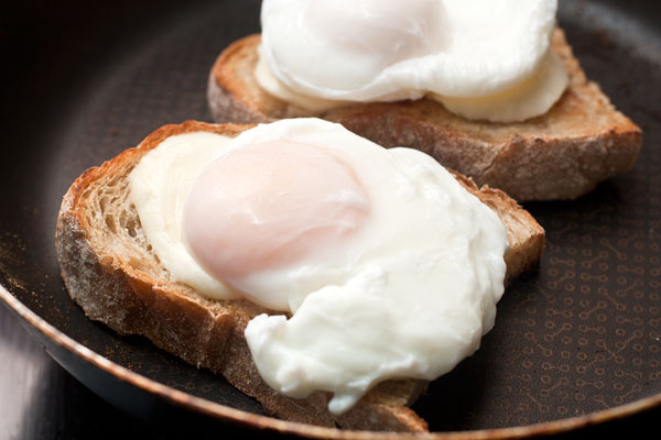 Готовые яйца выньте из кастрюли шумовкой, положите шумовку вместе с яйцом на чистое полотенце, чтобы впитались излишки воды.  Яйцо уложите поверх сыра.