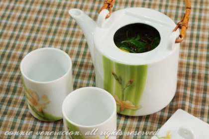 Выложить дольку лимона в чайник с зеленым чаем. Добавить листики мяты. Растираем мяту пальцами для более насыщенного аромата.