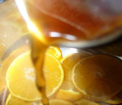 Лимон и апельсин хорошо помыть холодной водой и нарезать тонкими ломтиками. Переложить в кастрюлю нарезанные цитрусовые на одну минуту.