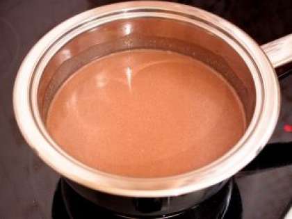 В кастрюлю с молоком добавить шоколад, аккуратно перемешать ложкой до полного растворения шоколада.