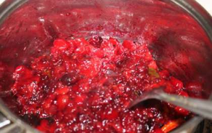 Получившееся ягодное пюре перекладываем в эмалированную кастрюлю и заливаем горячей водой. Ставим посуду на средний огонь, доводим до кипения и варим клюкву еще 6 минут.