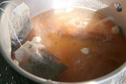 Сервировочный чайник обдайте кипятком или залейте на 7 минут кипятком, для того чтобы он нагрелся.  Необходимое количество молока доведите до кипения. На подготовленный сервировочный чайник установите мелкое сито и влейте заваренный черный чай. Сразу же добавьте сахар и перемешайте все деревянной ложкой. Теперь добавьте горячее молоко, перемешайте и накройте чайник крышкой.