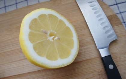 Дать завариться минут 7. Возьмем лимон. Хорошо его помоем и, не очищая от цедры,  разрежем лимон на две половины.