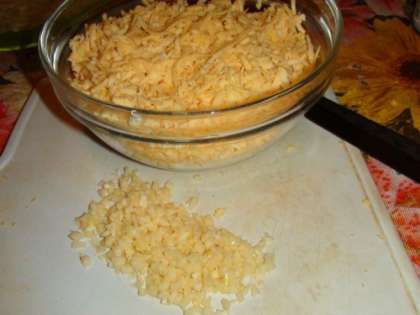 Консервированную рыбу разомните хорошенько вилкой и смешайте с майонезом. Сыр натрите на крупной терке и добавьте измельченный чеснок, заправьте массу майонезом. Тщательно перемешайте.