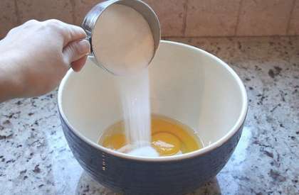 Затем  растопим сливочное масло на огне в кастрюле. Выключить конфорку и отставить масло остыть.Разбить яйца в глубокую посуду. Высыпать в нее сахар и ванилин. Перемешать все компоненты с помощью ручного венчика, пока не растает сахар.