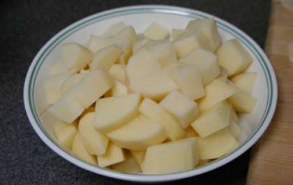 Очистить картофель от кожуры и промыть водой. Нарезать небольшими кусочками. Чтобы картофель не потемнел, зальем его водой.
