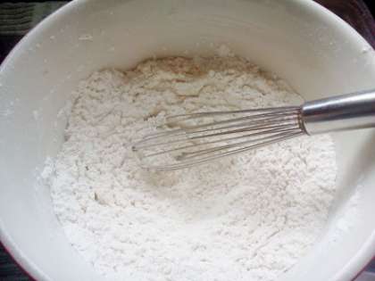 С помощью сита просеять муку в глубокую миску, добавить разрыхлитель, соль и перемешать.