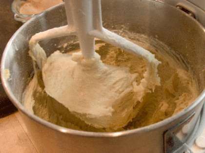 В кухонный комбайн положить сливочное масло с сахаром. Перемешать до однородности, используя при этом насадку для замеса теста. Добавить яйца. А затем - нарезанную мякоть апельсина, цедру,  орехи и муку. Замесить тесто.