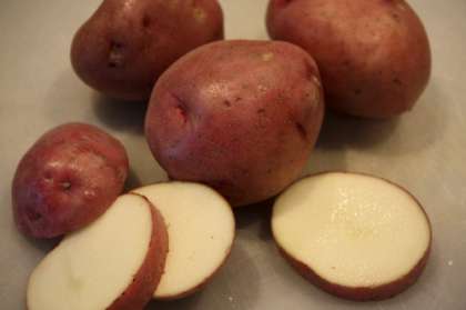 Для этого рецепта используем молодой картофель с кожурой. Сначала картофель нужно помыть. Затем высушить бумажным кухонным полотенцем. Нарезать нетолстыми кружочками и  уложить в глубокую тарелку.