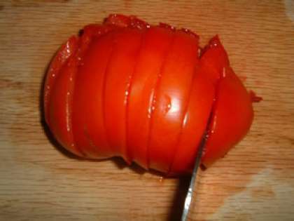 Промыть помидор и нарезать его на небольшие кусочки.