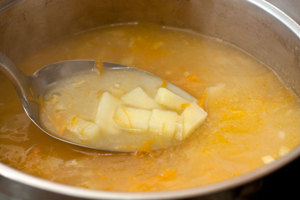 Когда картофель будет почти готов, добавьте в суп морковно-луковую и мучную смеси.