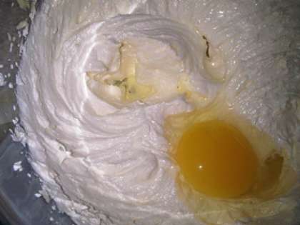 Вбить с помощью миксера куриные яйца со сметаной. Затем в это смесь добавить маргарин, муку с разрыхлителем и сахар. Перемешать тесто и дать настояться минут 5.