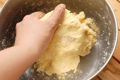 Затем влить кипяченую охлажденную воду в миску. Замесить тесто руками. Готовое тесто разделим на две части. Часть, которая больше, будем использовать для основы пирога, а поменьше - для оформления. Тесто оставить в холодильнике минут на 40.