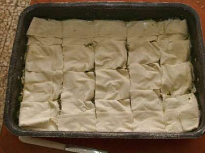 Нарезать пирог небольшими порционными кусками, так как после запекания тесто очень сложно режется. Нагреть до температуры 200°С духовку и отправить туда пирог минут на 20. Затем уменьшаем температуру духовки до 175°С и печем еще 15 минут.