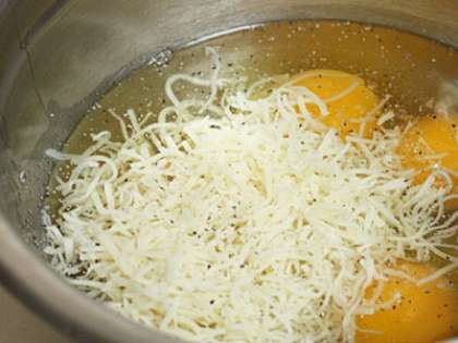 Включить и разогреть духовку до 200 градусов. Готовим заливку. В миску вбить яйца, добавить столовую ложку муки, немного молока, взбить массу венчиком до пышности и ввести в нее сыр.
